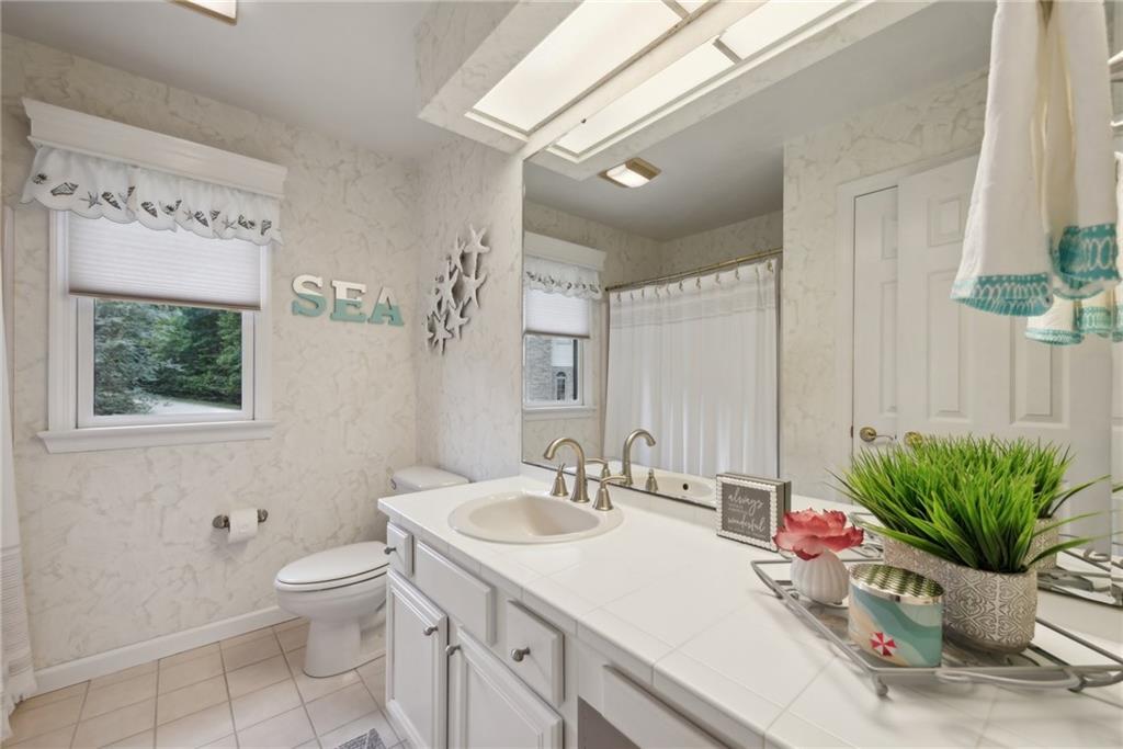 1107 Laurelview Drive Latrobe, PA 15650 - Photo 40 of 50 a bathroom with a granite countertop sink a large mirror a toilet and a shower