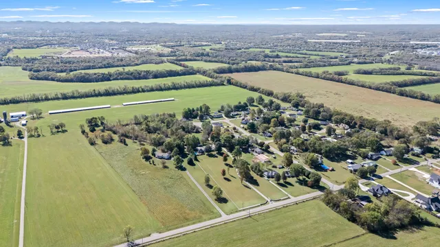 a view of an empty room with wooden floor fireplace and a window