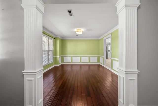 a view of a livingroom with a flat screen tv wooden floor and a ceiling fan