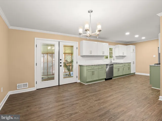 a kitchen with granite countertop cabinets stainless steel appliances a sink and wooden floor