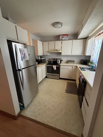 a kitchen with a refrigerator a stove top oven and a sink