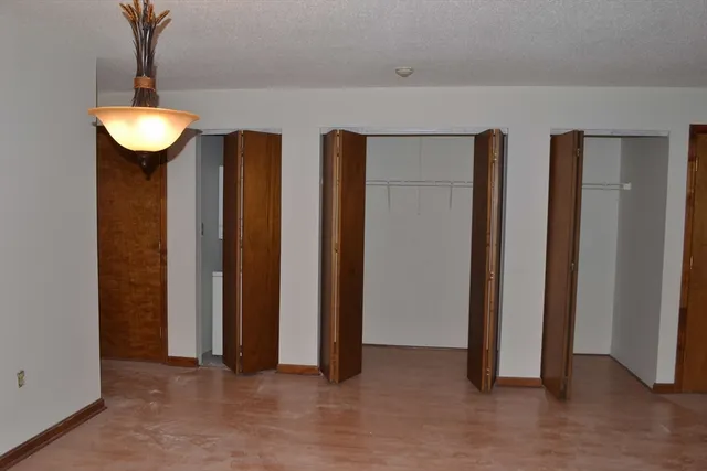 an empty room with closet and a window