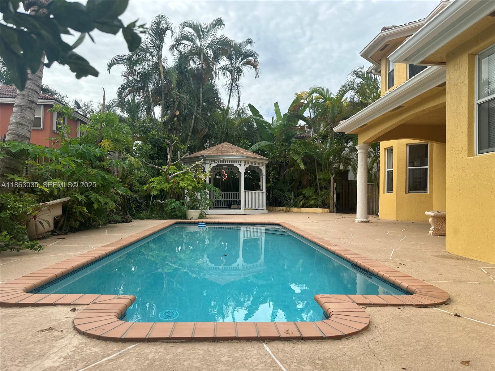 6049 Southwest 165th Avenue Miami, FL 33193 - Photo 13 of 47 a view of a swimming pool with a patio