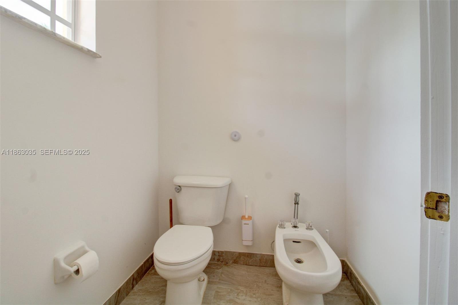 6049 Southwest 165th Avenue Miami, FL 33193 - Photo 26 of 47 a toilet sitting in a bathroom next to a wooden wall