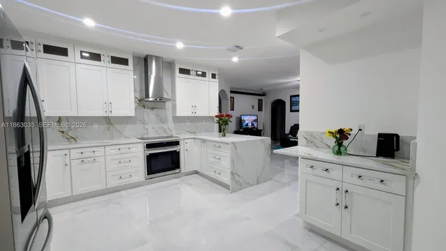 a room with stainless steel appliances kitchen island granite countertop furniture and a large window