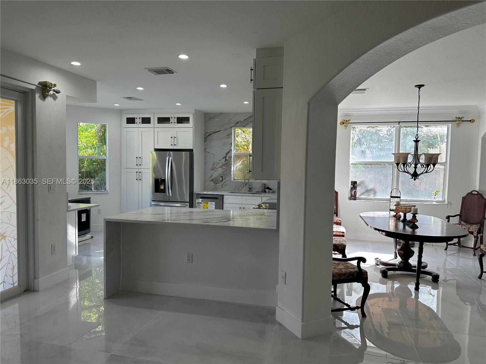 6049 Southwest 165th Avenue Miami, FL 33193 - Photo 4 of 47 a kitchen with stainless steel appliances kitchen island granite countertop a refrigerator and a sink