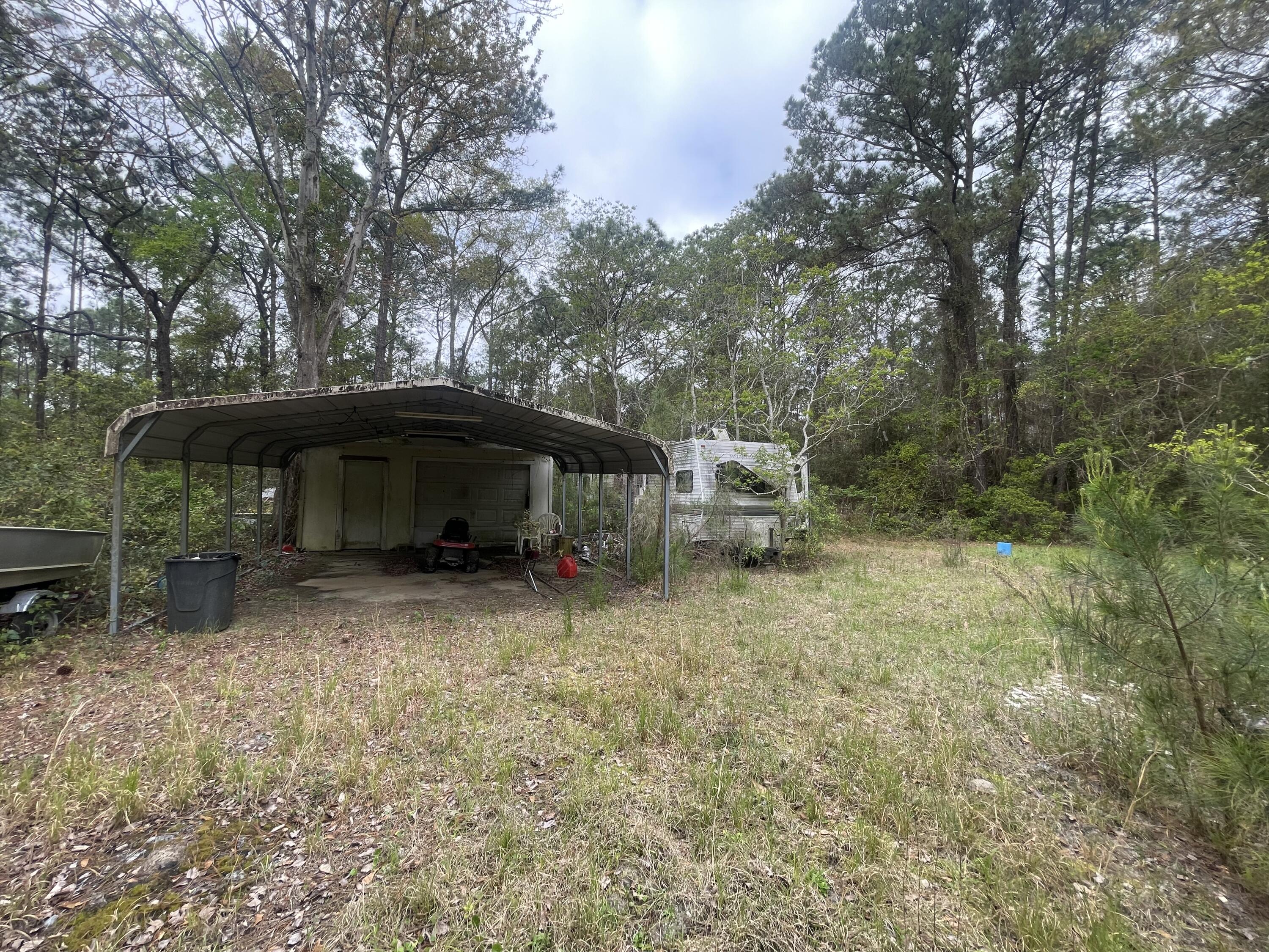 93 Laird Drive Freeport, FL 32439 - Photo 10 of 12 a view of a house with a yard and hanging chair