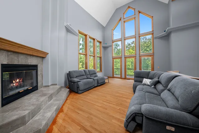 a living room with furniture fireplace and a large window