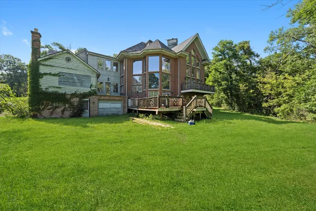 a view of a big house with a big yard and large trees