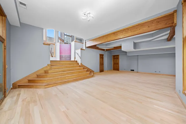 a spacious bedroom with a bed and a ceiling fan