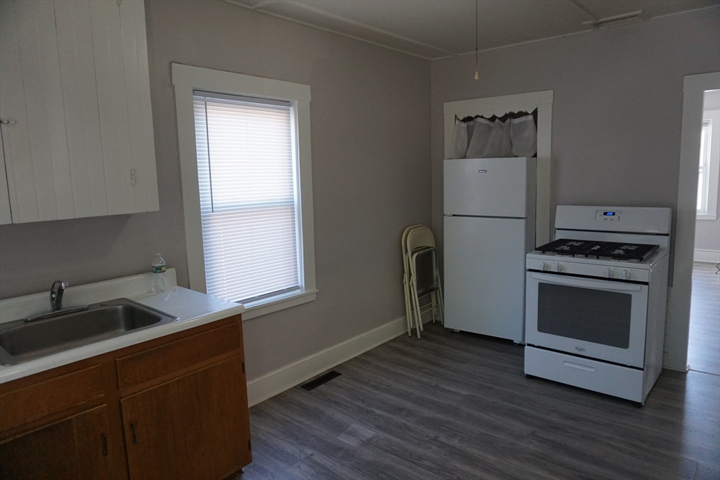 5-7 Summer Street Maynard, MA 01754 - Photo 5 of 28 a kitchen with a sink a microwave a stove and refrigerator