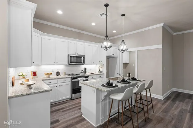 a kitchen with stainless steel appliances kitchen island a white table and chairs in it