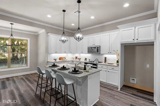 a kitchen with stainless steel appliances kitchen island granite countertop a stove a sink and a refrigerator