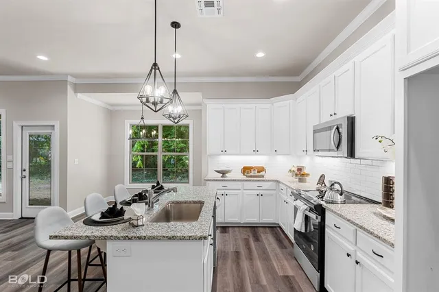 a kitchen with stainless steel appliances granite countertop a sink stove and cabinets