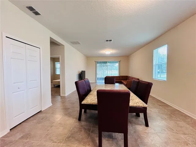 a living room with furniture and a dining table with kitchen view