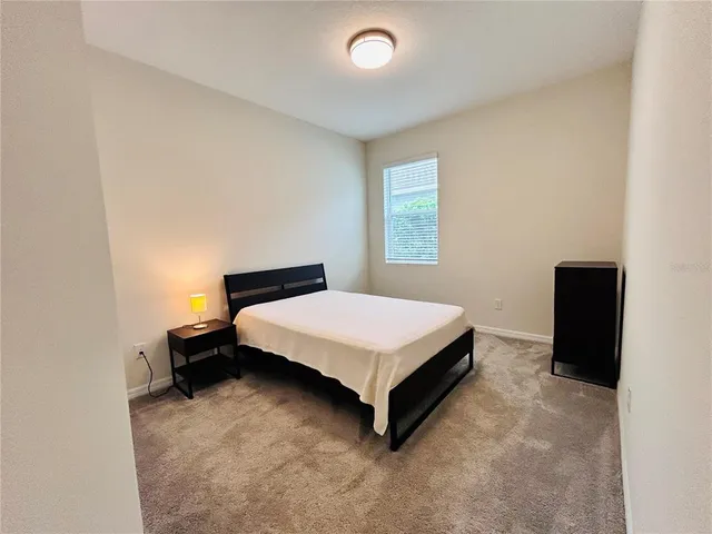 a living room with a couch and a dresser next to a window