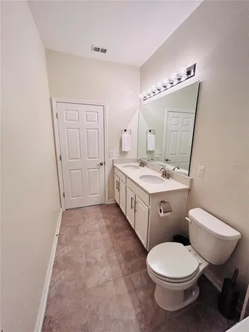 a spacious bathroom with a double vanity sink mirror and toilet