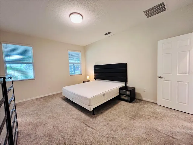 a view of an empty room with large windows and a balcony