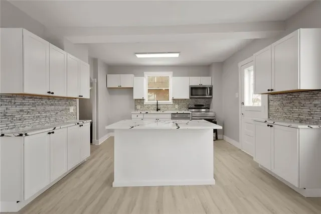a kitchen with stainless steel appliances a sink stove top oven and cabinets