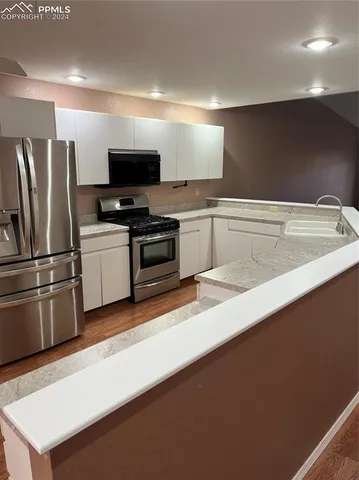 a kitchen with stainless steel appliances a microwave a stove and a refrigerator