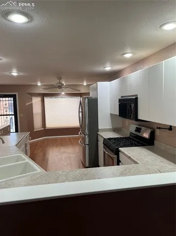 a kitchen with stainless steel appliances granite countertop a sink and a stove