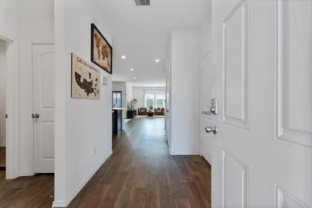a view of a hallway with wooden floor