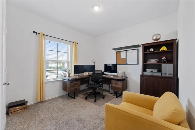 a view of a livingroom with workspace and a window