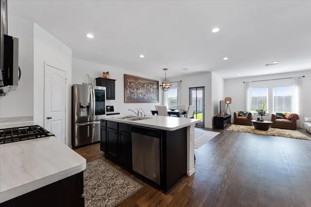 a kitchen with sink stove and refrigerator