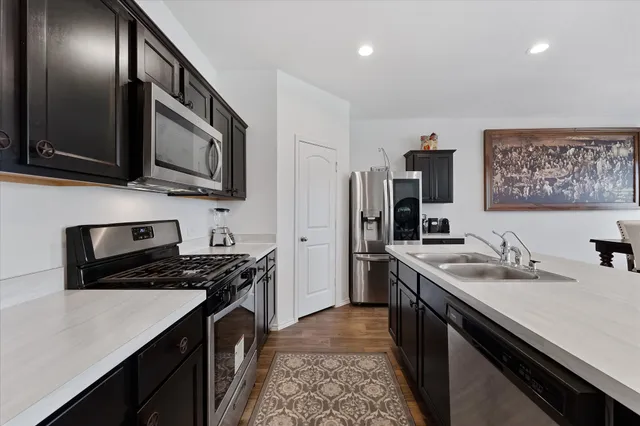 a kitchen with stainless steel appliances granite countertop a sink stove and refrigerator