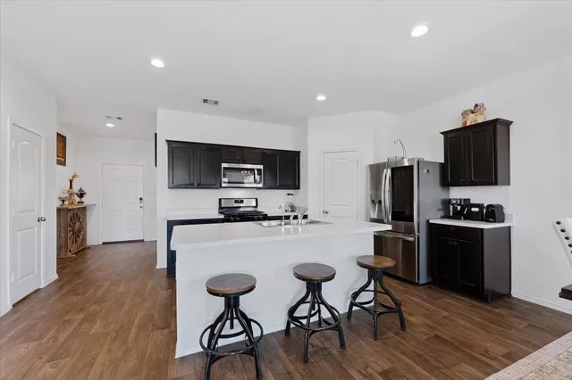 a kitchen with stainless steel appliances a stove top oven a refrigerator a sink and a refrigerator