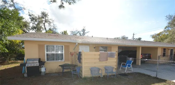 a view of a house with a patio and a yard