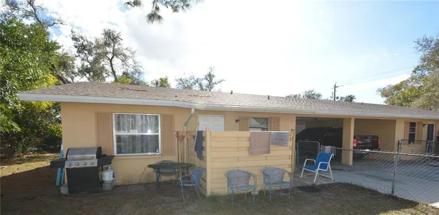 a view of a house with a patio and a yard