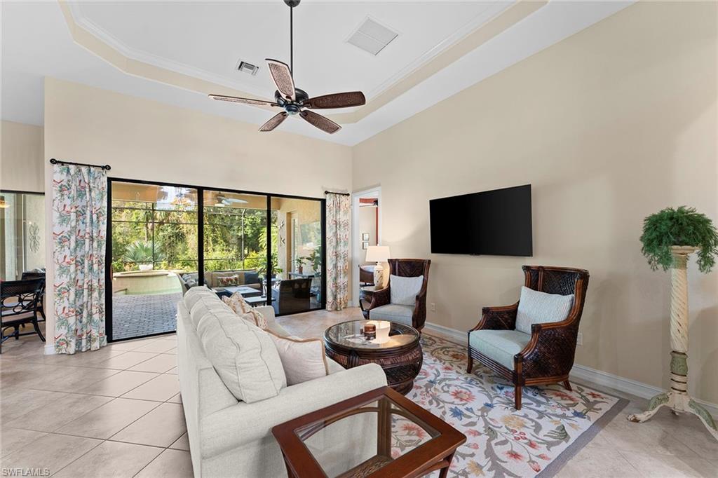 8838 Lely Island Circle Naples, FL 34113 - Photo 11 of 47 a living room with furniture and a flat screen tv