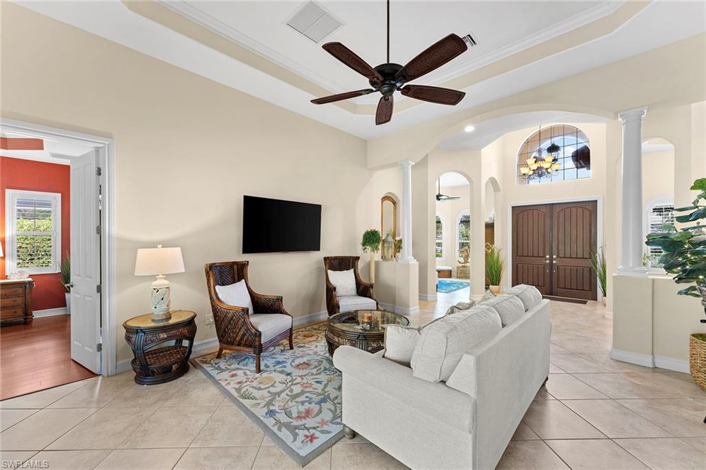 8838 Lely Island Circle Naples, FL 34113 - Photo 12 of 47 a living room with furniture and a chandelier