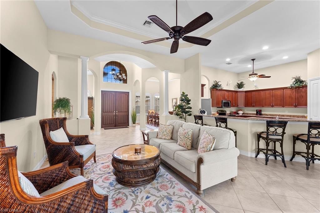 8838 Lely Island Circle Naples, FL 34113 - Photo 13 of 47 a living room with furniture kitchen view and a chandelier