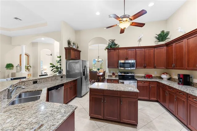 a kitchen with kitchen island granite countertop a sink stove and refrigerator