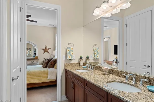 a en suite bathroom with a granite countertop sink and a mirror