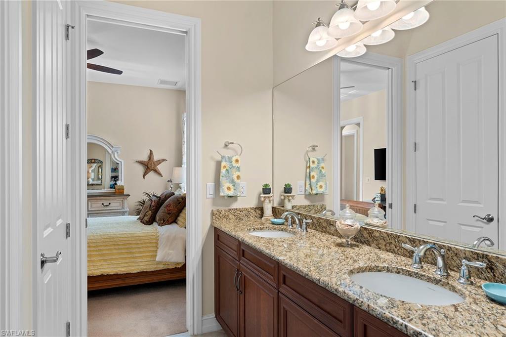 8838 Lely Island Circle Naples, FL 34113 - Photo 27 of 47 a en suite bathroom with a granite countertop sink and a mirror