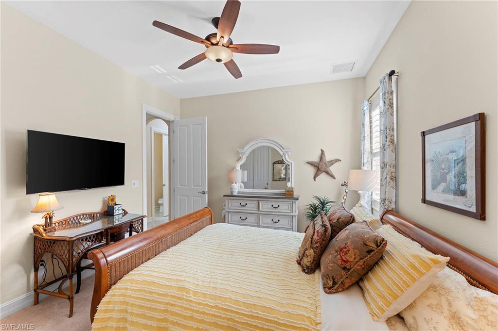 8838 Lely Island Circle Naples, FL 34113 - Photo 29 of 47 a bedroom with a bed and a flat screen tv