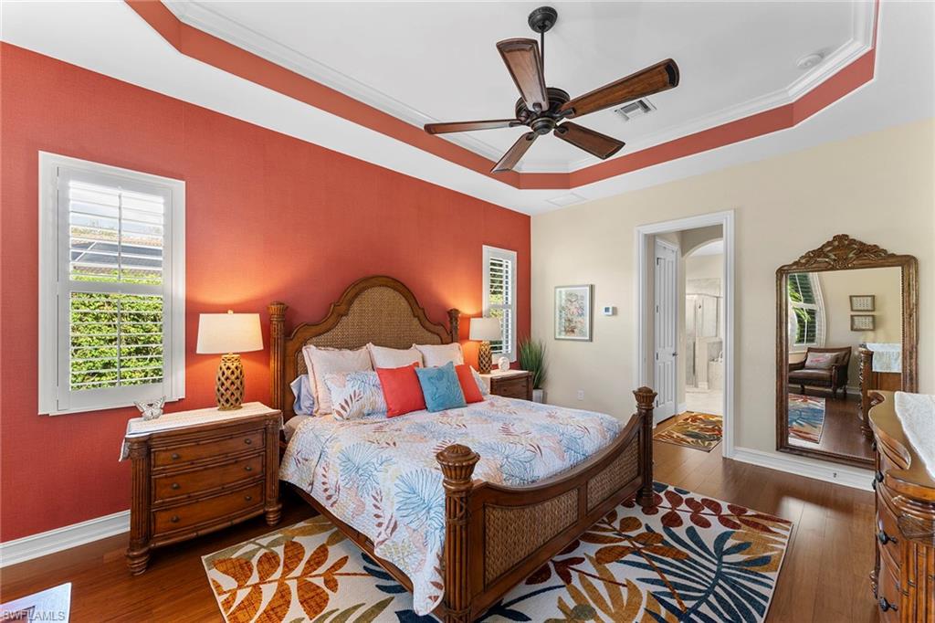 8838 Lely Island Circle Naples, FL 34113 - Photo 32 of 47 a bedroom with a bed and wooden floor