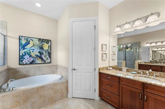 a spacious bathroom with a tub a double vanity sink and a mirror