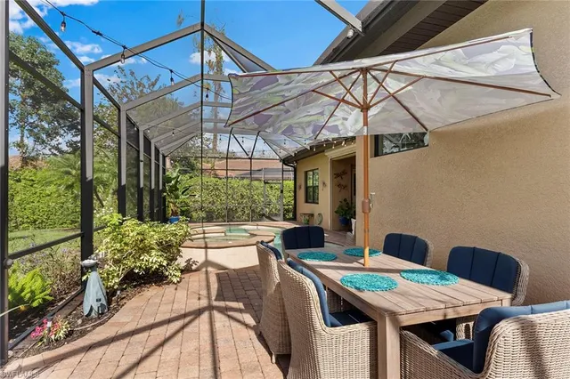 a view of a patio with table and chairs under an umbrella