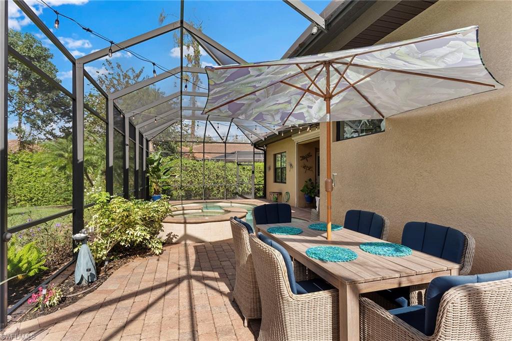 8838 Lely Island Circle Naples, FL 34113 - Photo 41 of 47 a view of a patio with table and chairs under an umbrella