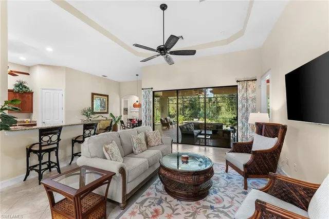 a living room with furniture a flat screen tv and a large window