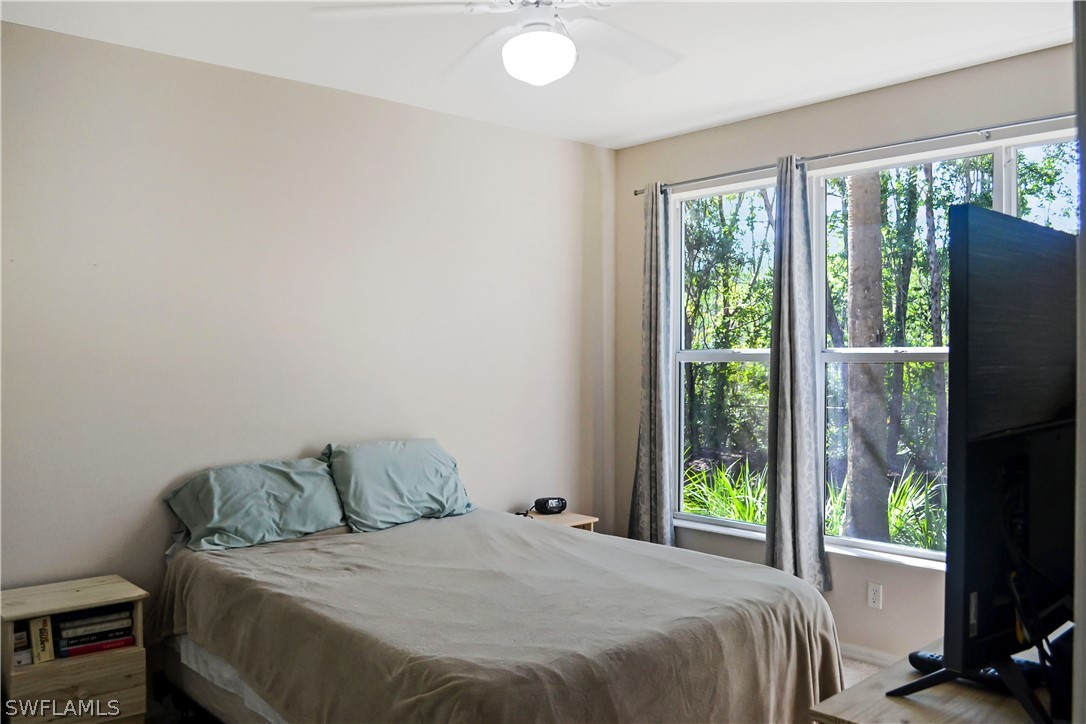 9048 Triangle Palms Lane, Unit 1106 Fort Myers, FL 33913 - Photo 14 of 29 a bedroom with a bed and a flat tv screen next to a window