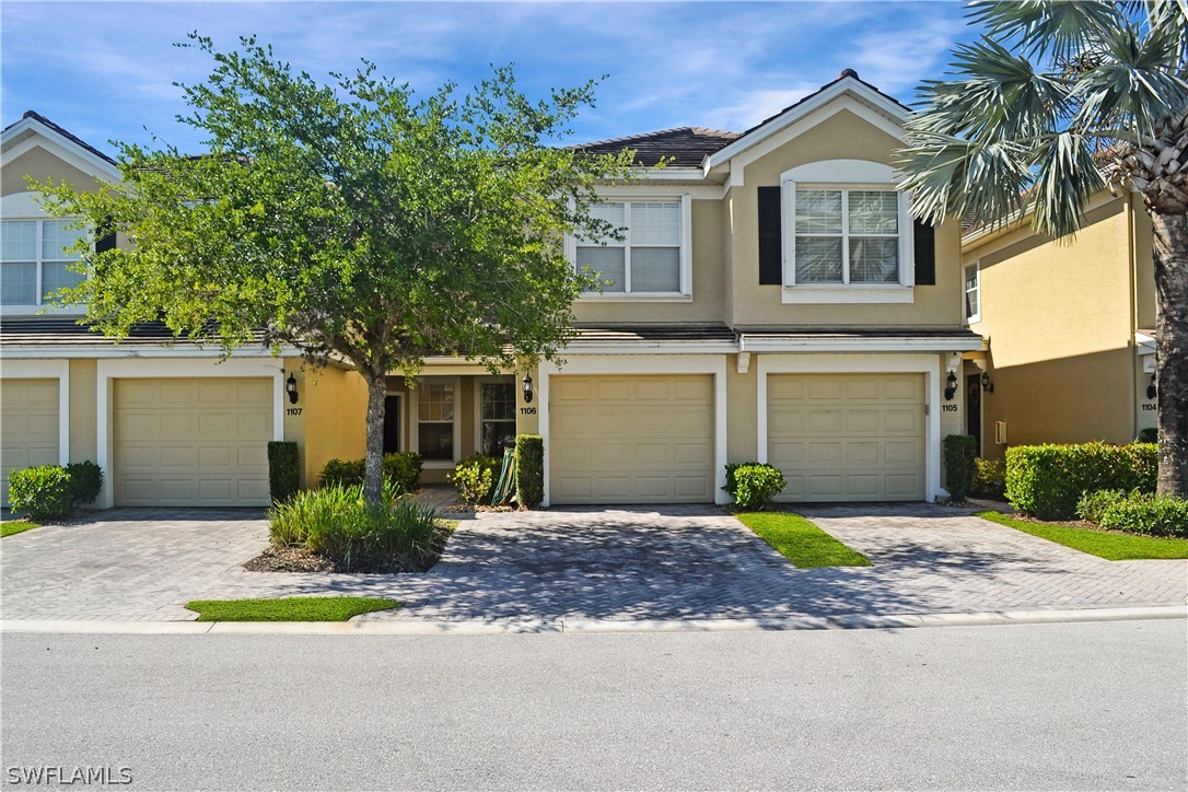 9048 Triangle Palms Lane, Unit 1106 Fort Myers, FL 33913 - Photo 26 of 29 a front view of a house with a yard and garage