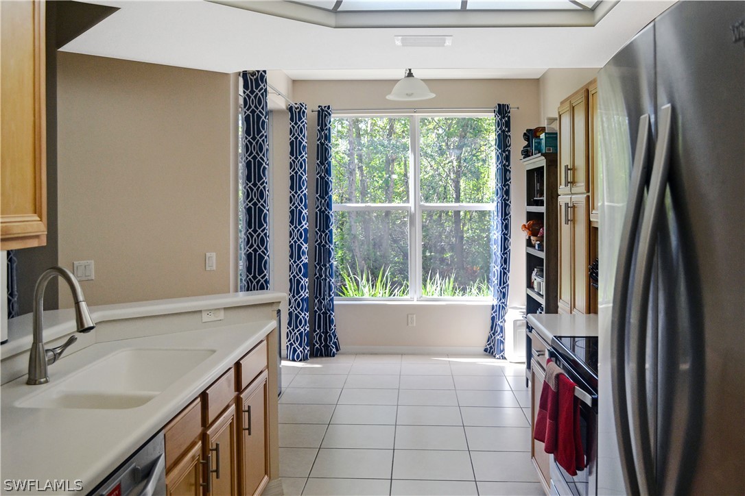 9048 Triangle Palms Lane, Unit 1106 Fort Myers, FL 33913 - Photo 8 of 29 a kitchen with a sink a stove and a refrigerator