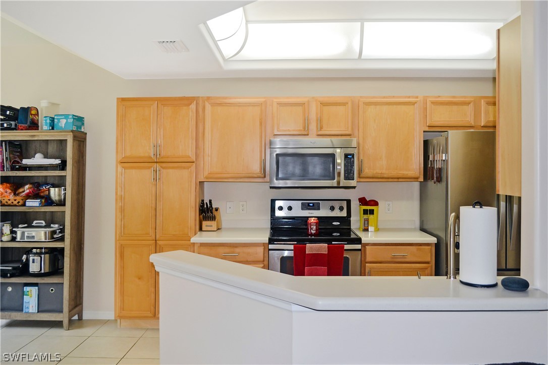 9048 Triangle Palms Lane, Unit 1106 Fort Myers, FL 33913 - Photo 9 of 29 a kitchen with stainless steel appliances a refrigerator and a stove