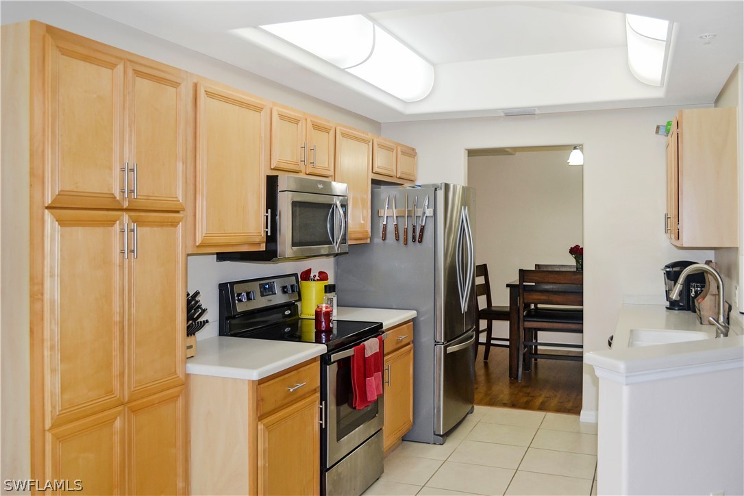 9048 Triangle Palms Lane, Unit 1106 Fort Myers, FL 33913 - Photo 10 of 29 a kitchen with stainless steel appliances a stove refrigerator and a sink