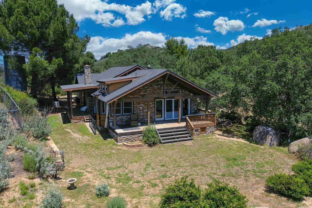 21057 Sutherland Dam Road Ramona, CA 92065 - Photo 17 of 66 a front view of house with yard and trees in the background